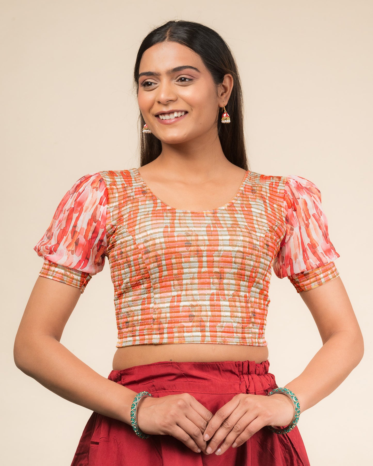 Model wearing a stretchable blouse with printed body, puff organza sleeves, and round neckline.