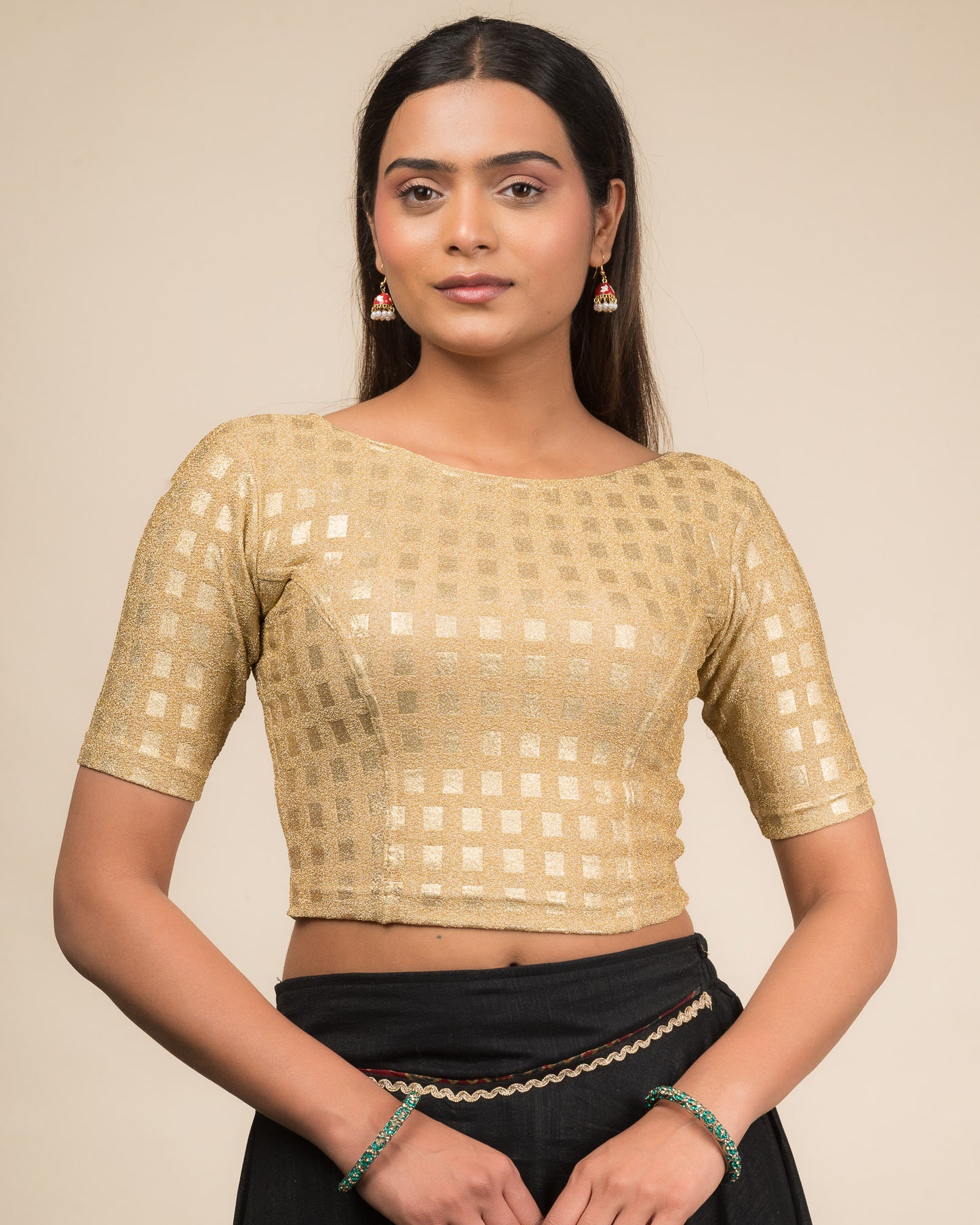 Model wearing a stretchable blouse with a boat neckline and elbow sleeves, featuring metallic embossed checks.