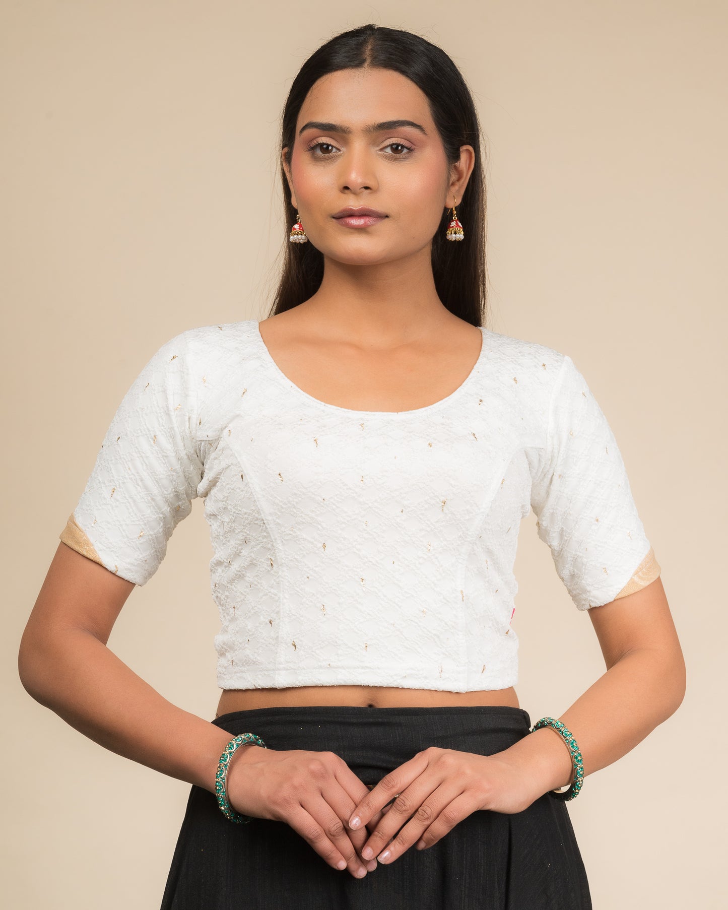 Model wearing a stretchable blouse with round neckline and elbow sleeves featuring metallic drop motifs.
