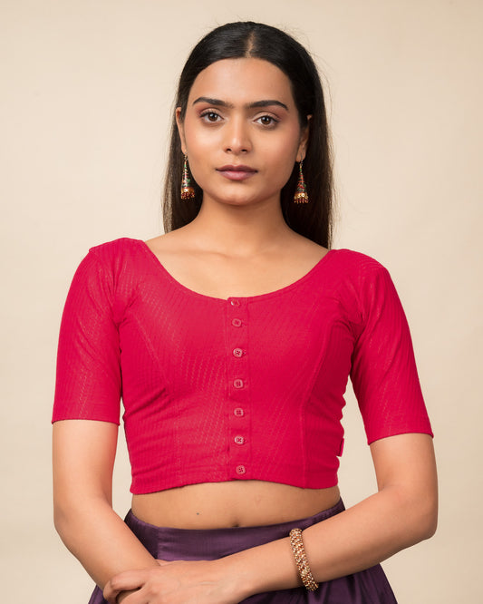 Model wearing a stretchable dobby-weave cotton blouse with elbow sleeves, round neckline, and front-button closure