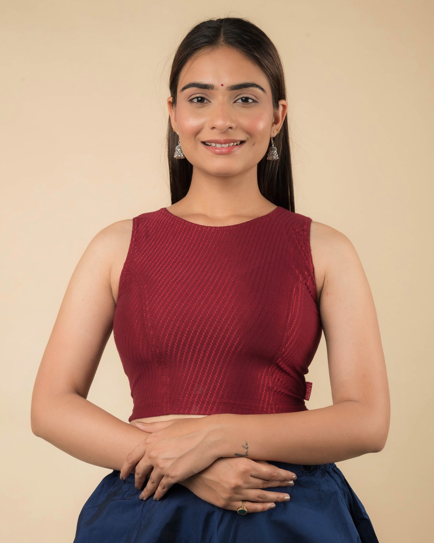 Model wearing a sleeveless stretchable cotton blouse with high neckline