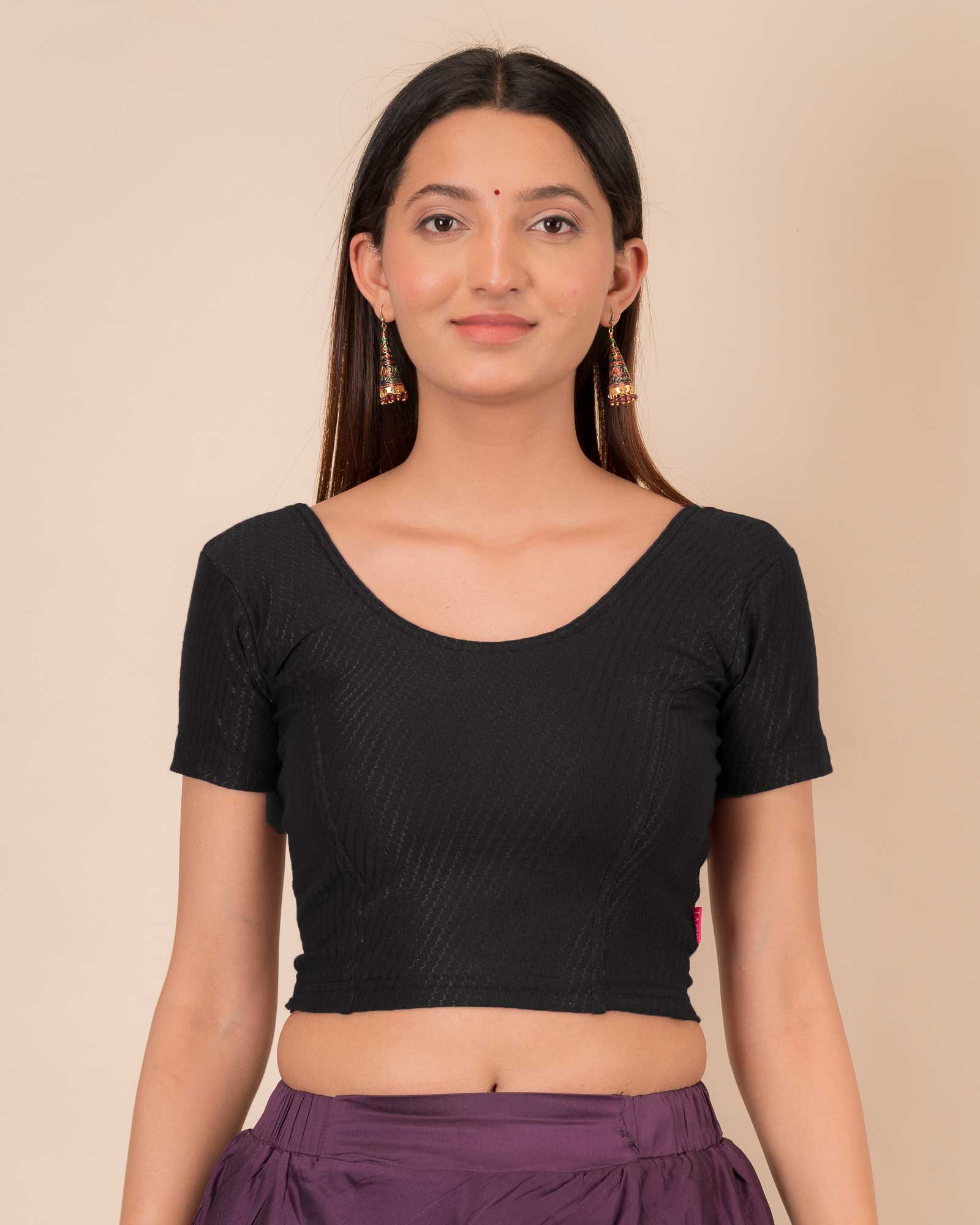  Model wearing a stretchable dobby cotton blouse with half sleeves and round neckline