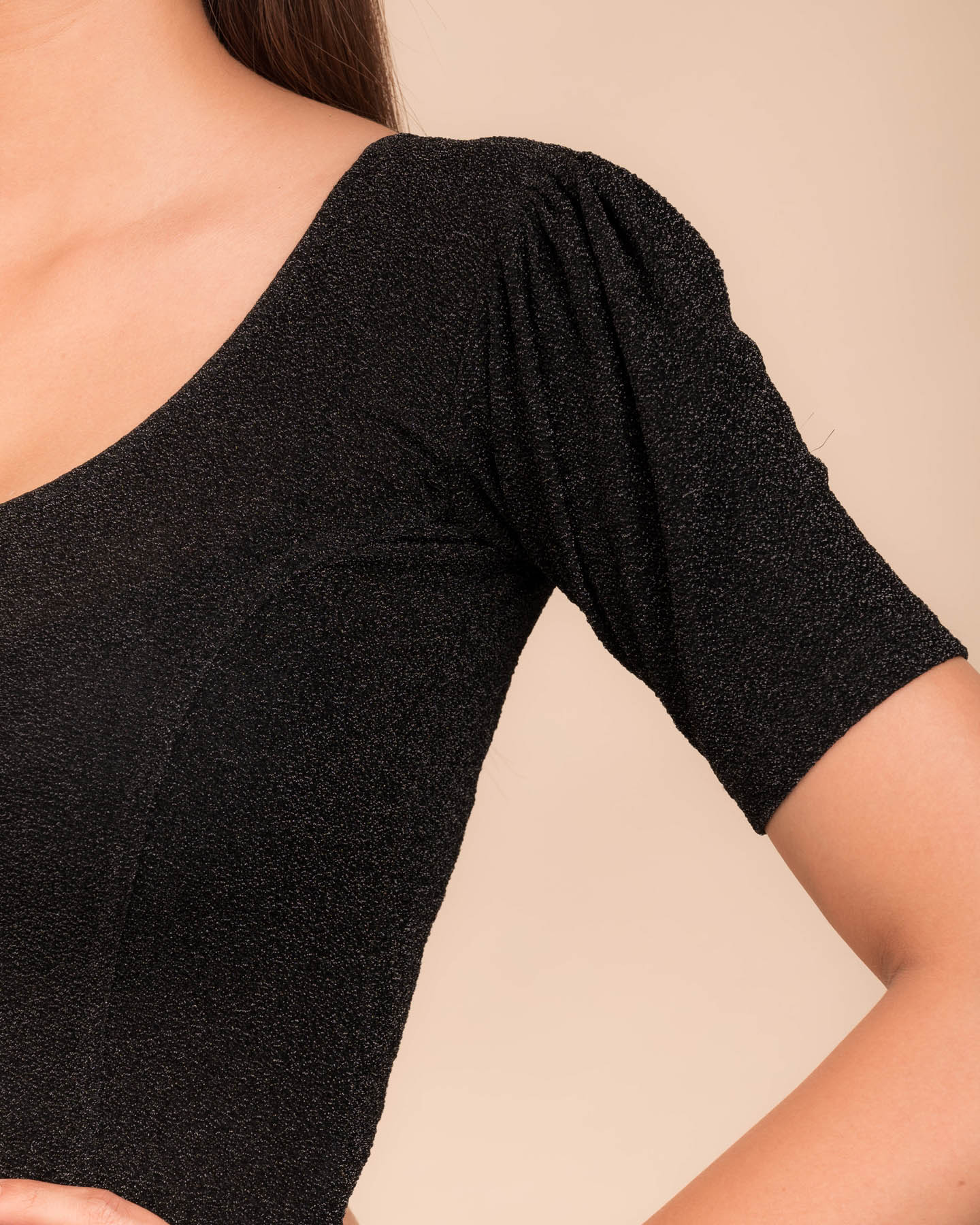 Close-up of the lurex fabric with fine pleating and subtle sheen
