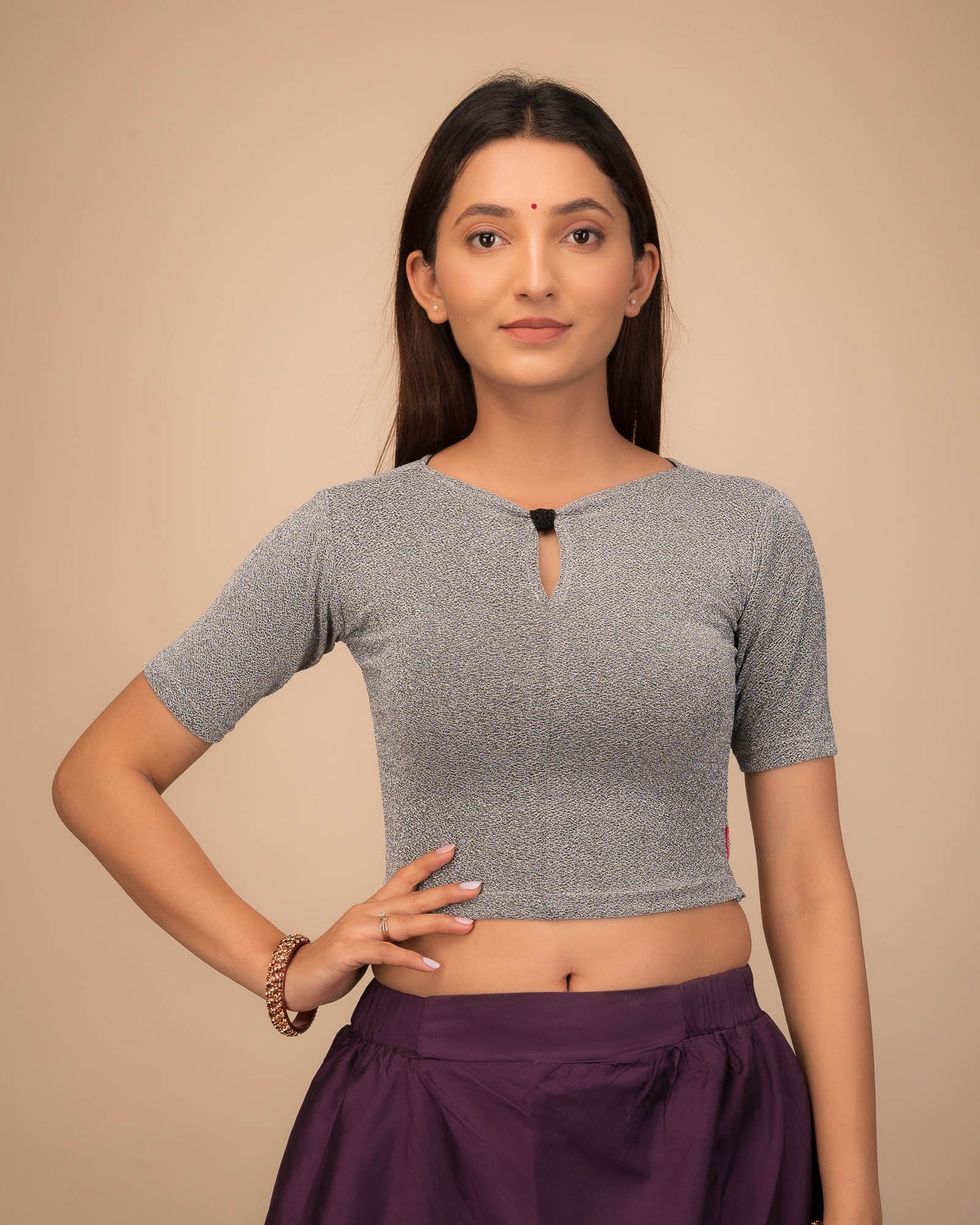 Model wearing a metallic-zari stretchable blouse with a bow-keyhole neckline and elbow sleeves