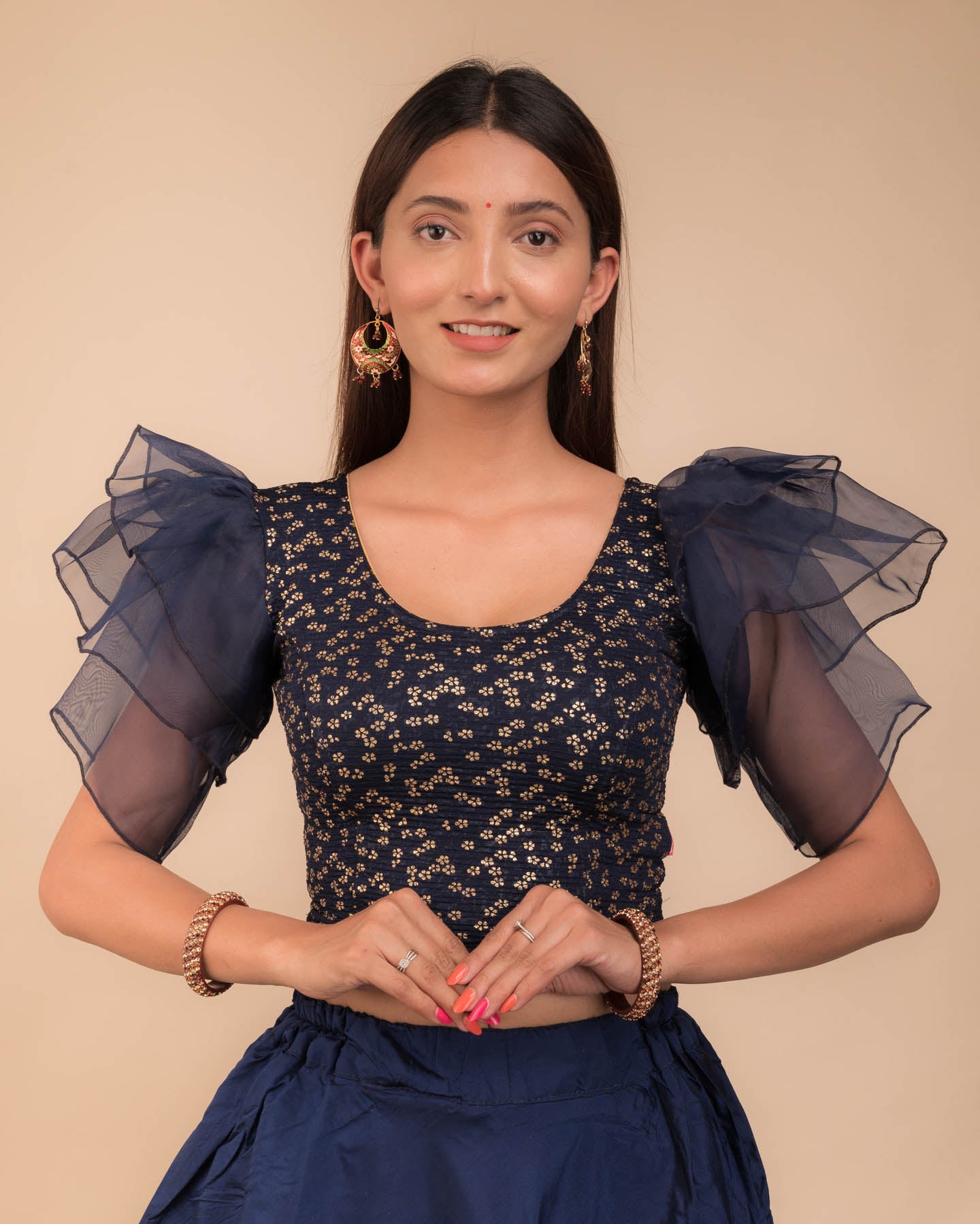 Model wearing an organza slip-on blouse with ruffled sleeves and round neckline