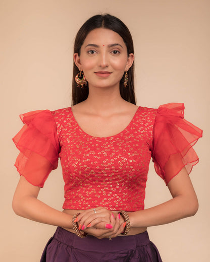 Model wearing an organza slip-on blouse with ruffled sleeves and round neckline