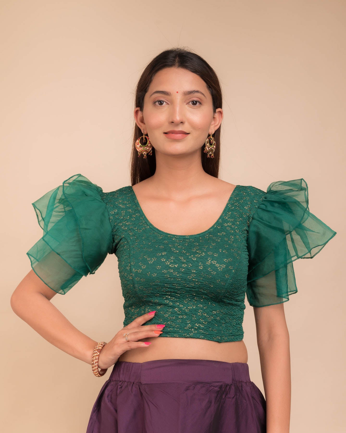 Model wearing an organza slip-on blouse with ruffled sleeves and round neckline