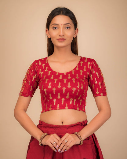 Model wearing a stretchable blouse with metallic gold print and zari embroidery, elbow sleeves, and round neckline