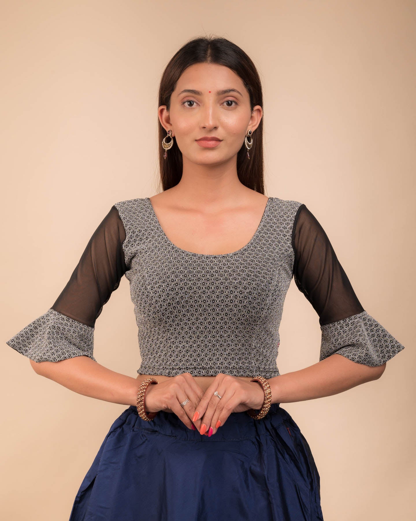 Model wearing a stretchable blouse featuring tonal zari flower appliqués, round neckline, and elbow sleeves