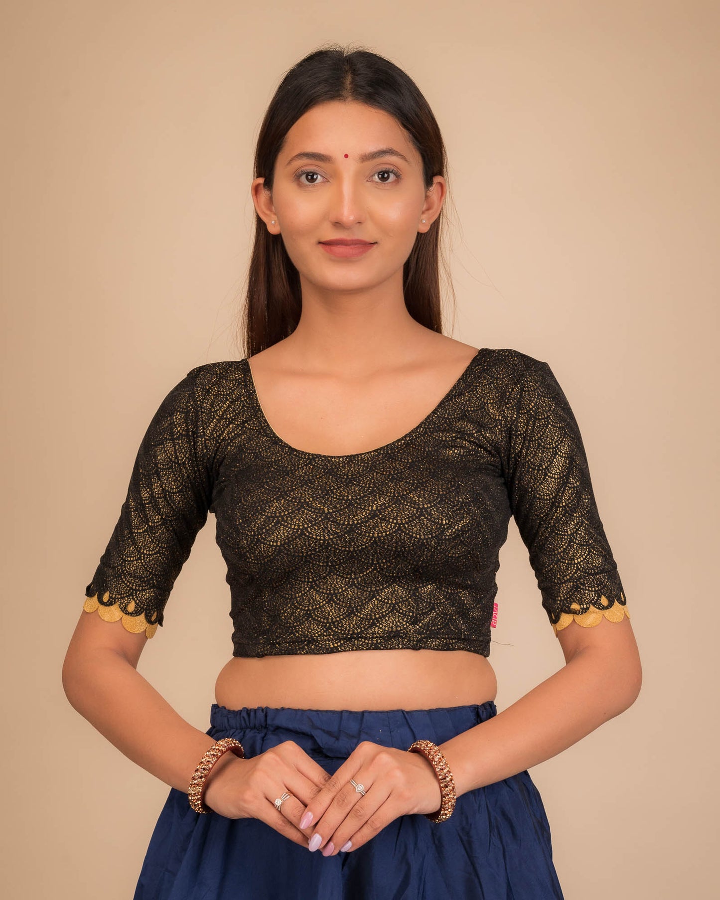 Model wearing a stretchable blouse with scallop-edged elbow sleeves and round neckline.