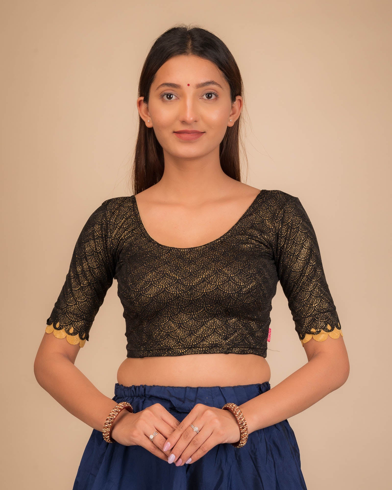 Model wearing a stretchable blouse with scallop-edged elbow sleeves and round neckline.