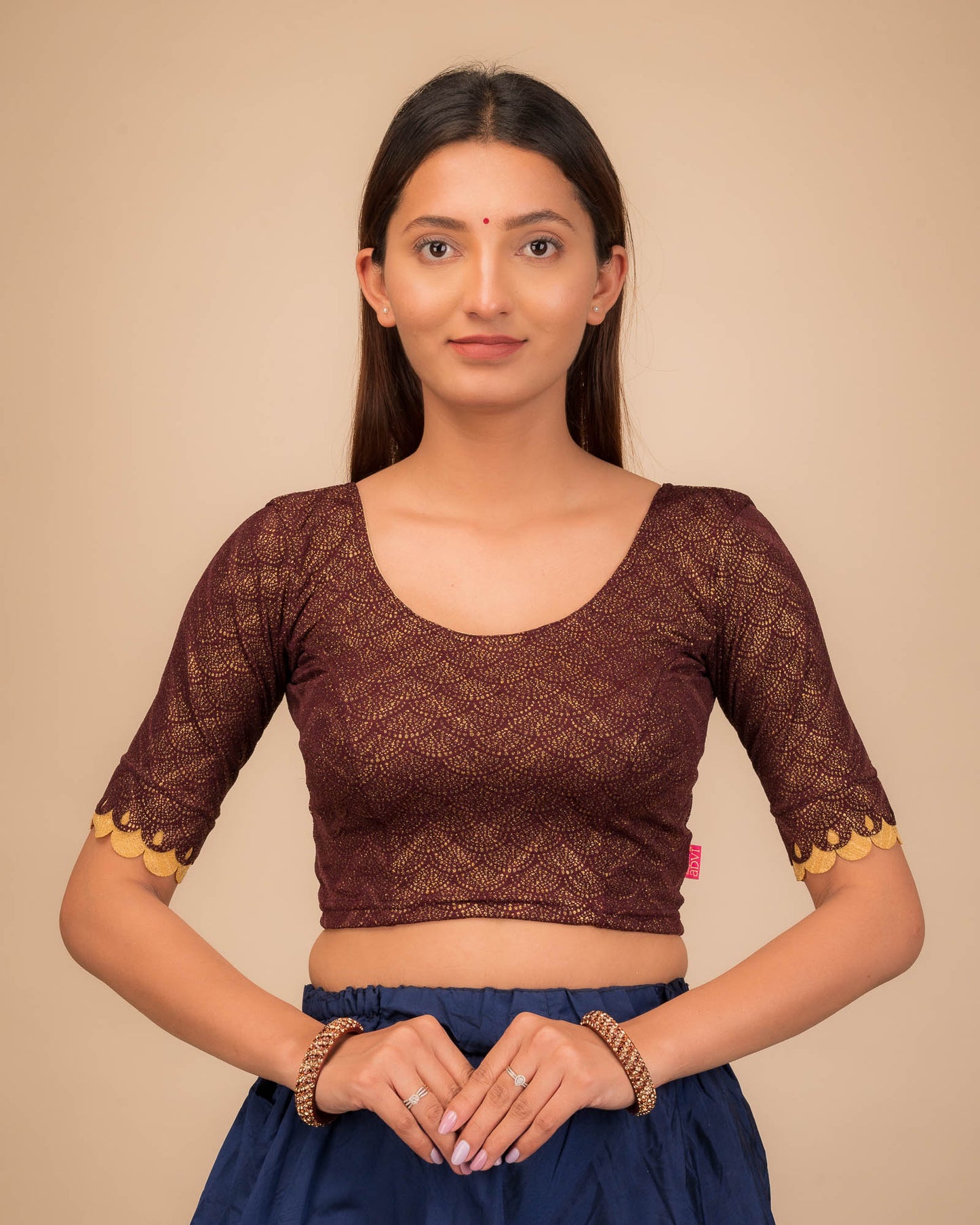 Model wearing a stretchable blouse with scallop-edged elbow sleeves and round neckline.