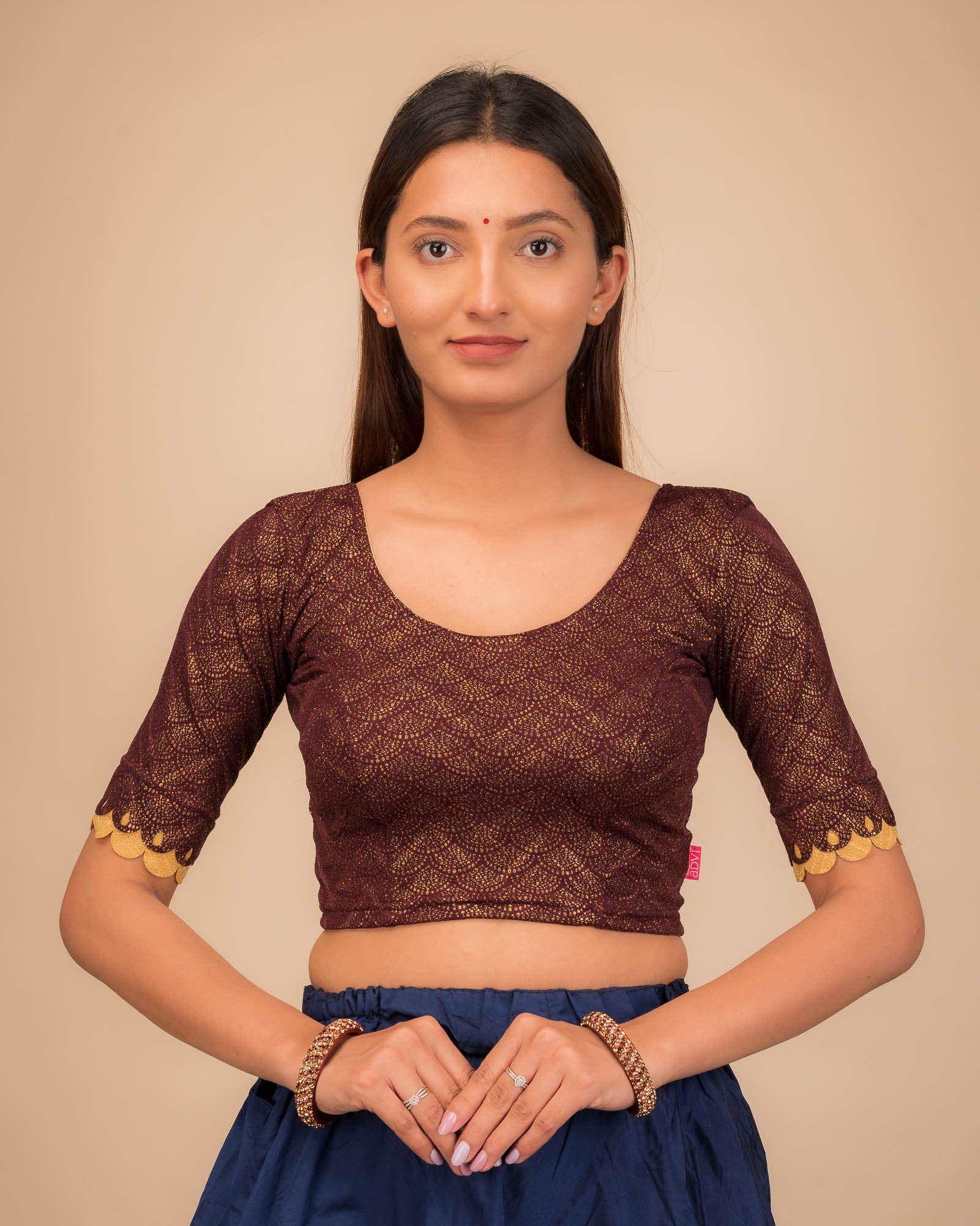 Model wearing a stretchable blouse with scallop-edged elbow sleeves and round neckline.