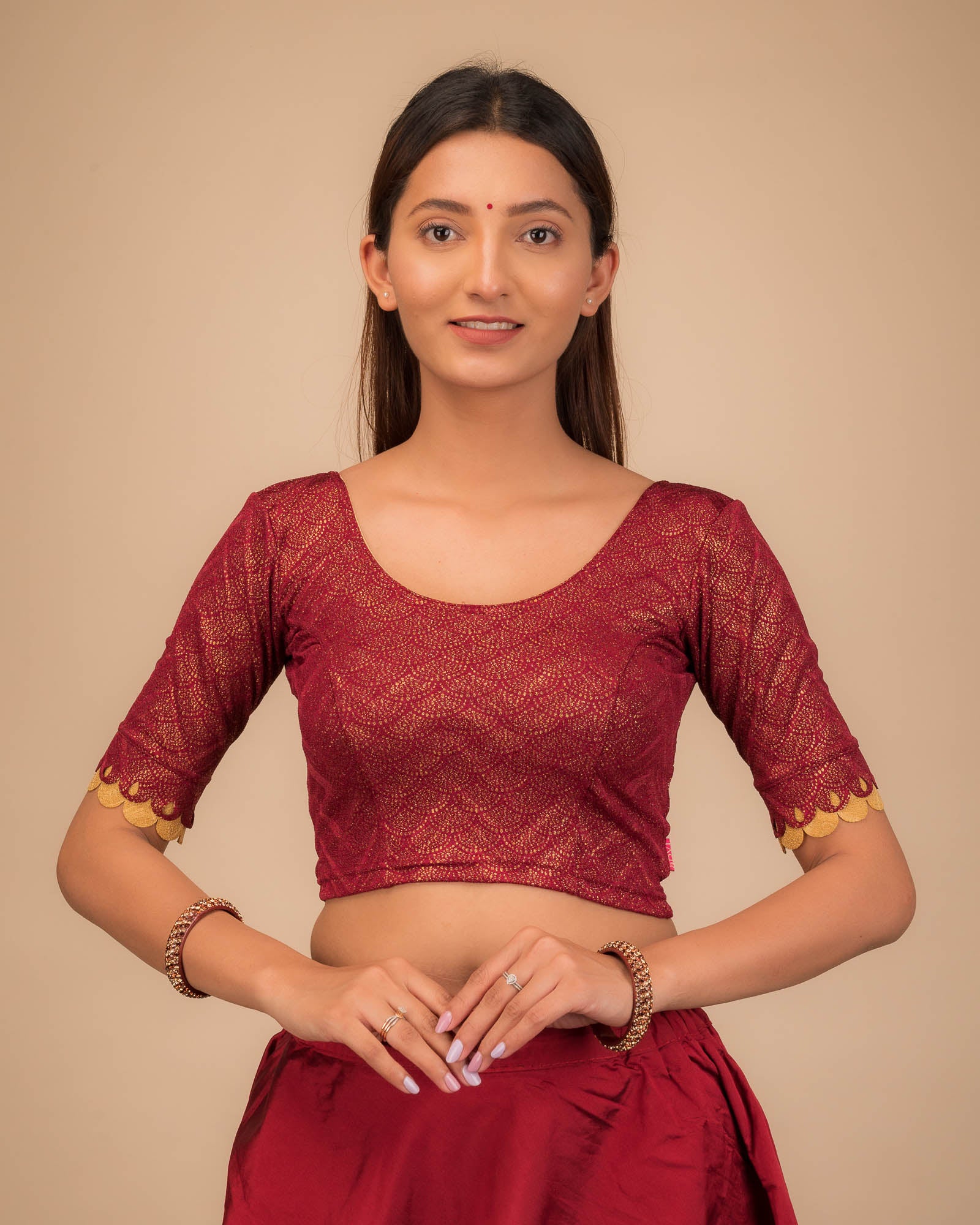 Model wearing a stretchable blouse with scallop-edged elbow sleeves and round neckline.