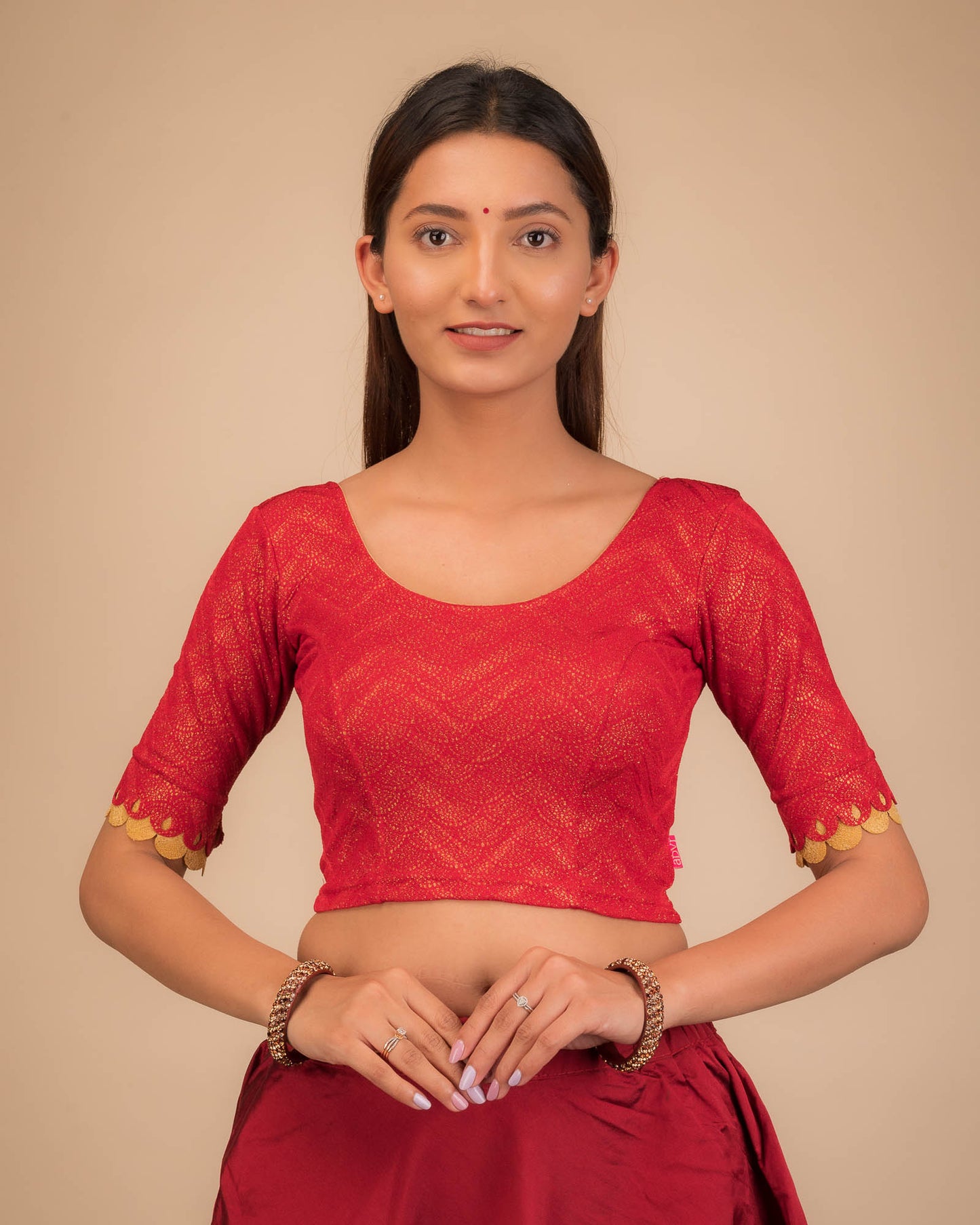 Model wearing a stretchable blouse with scallop-edged elbow sleeves and round neckline.