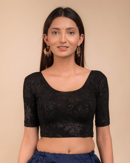 Model wearing a stretchable lurex blouse with elbow sleeves and round neckline, featuring delicate emboss details.