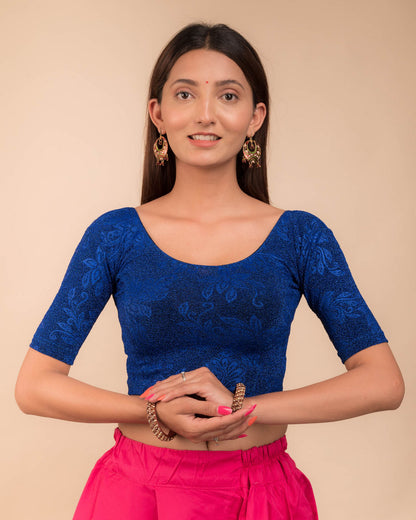 Model wearing a stretchable lurex blouse with elbow sleeves and round neckline, featuring delicate emboss details.