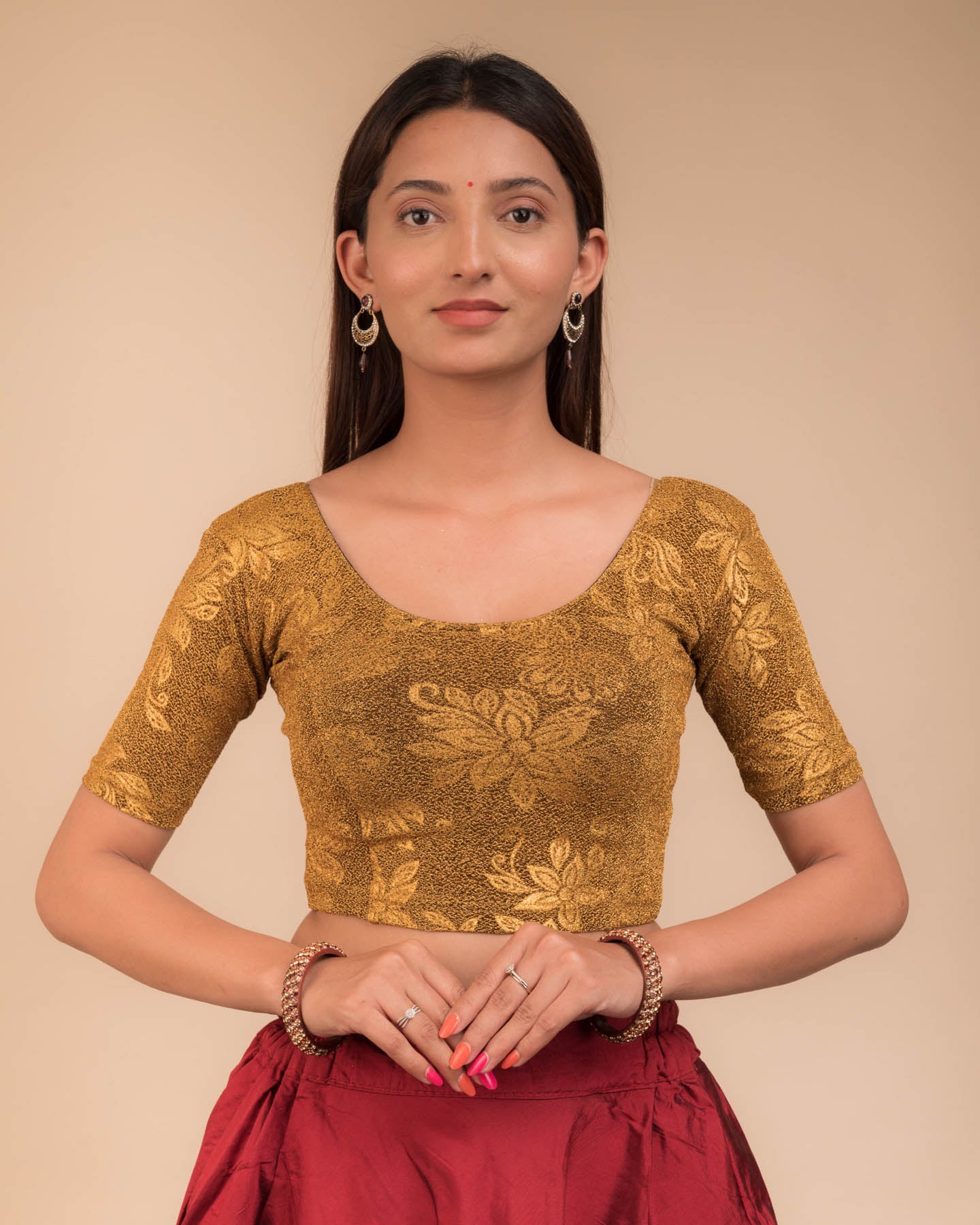 Model wearing a stretchable lurex blouse with elbow sleeves and round neckline, featuring delicate emboss details.
