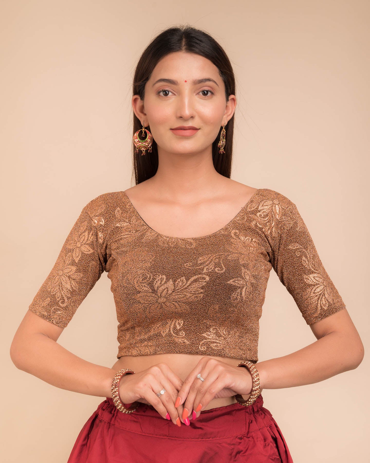 Model wearing a stretchable lurex blouse with elbow sleeves and round neckline, featuring delicate emboss details.
