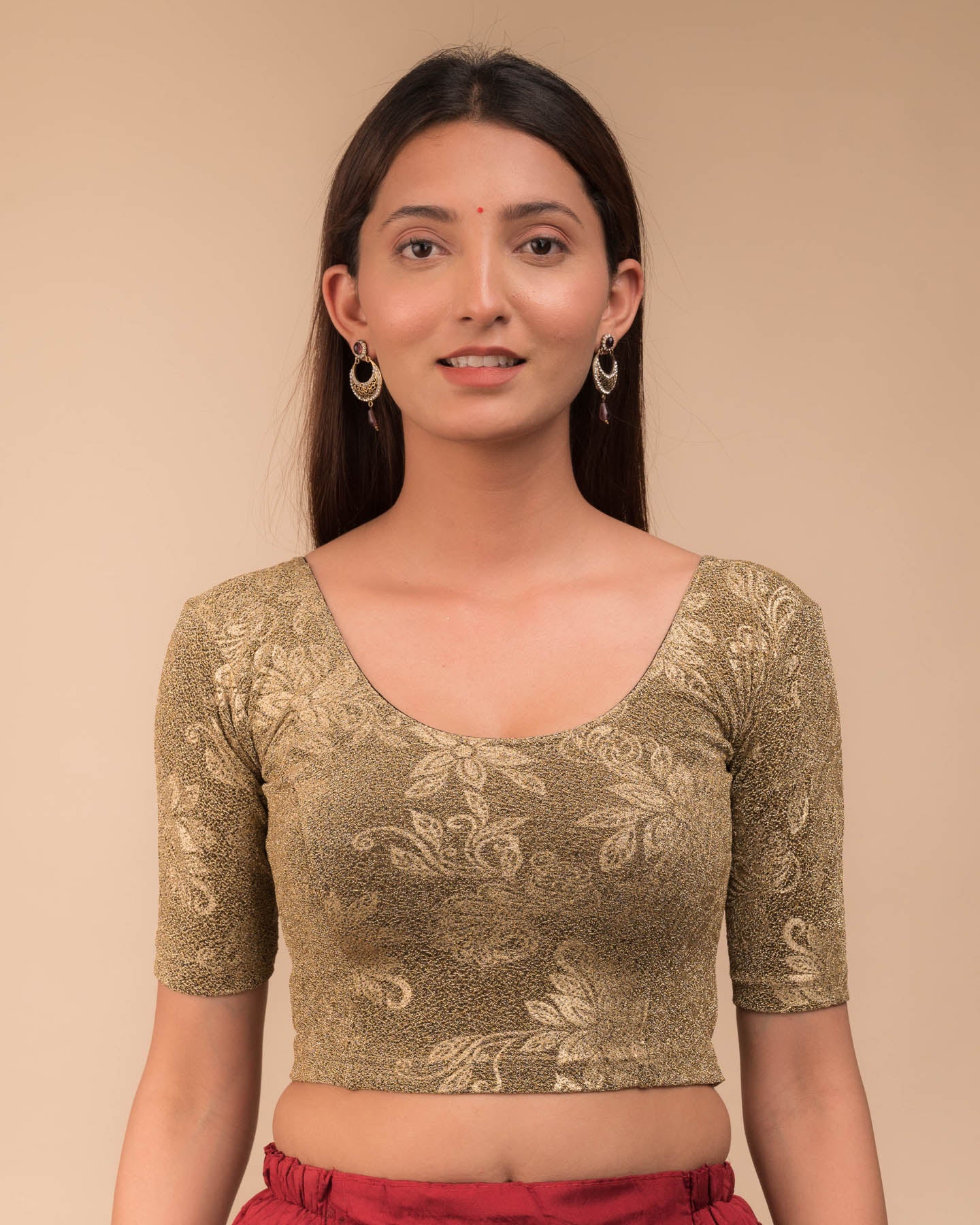 Model wearing a stretchable lurex blouse with elbow sleeves and round neckline, featuring delicate emboss details.