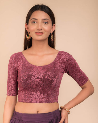 Model wearing a stretchable lurex blouse with elbow sleeves and round neckline, featuring delicate emboss details.