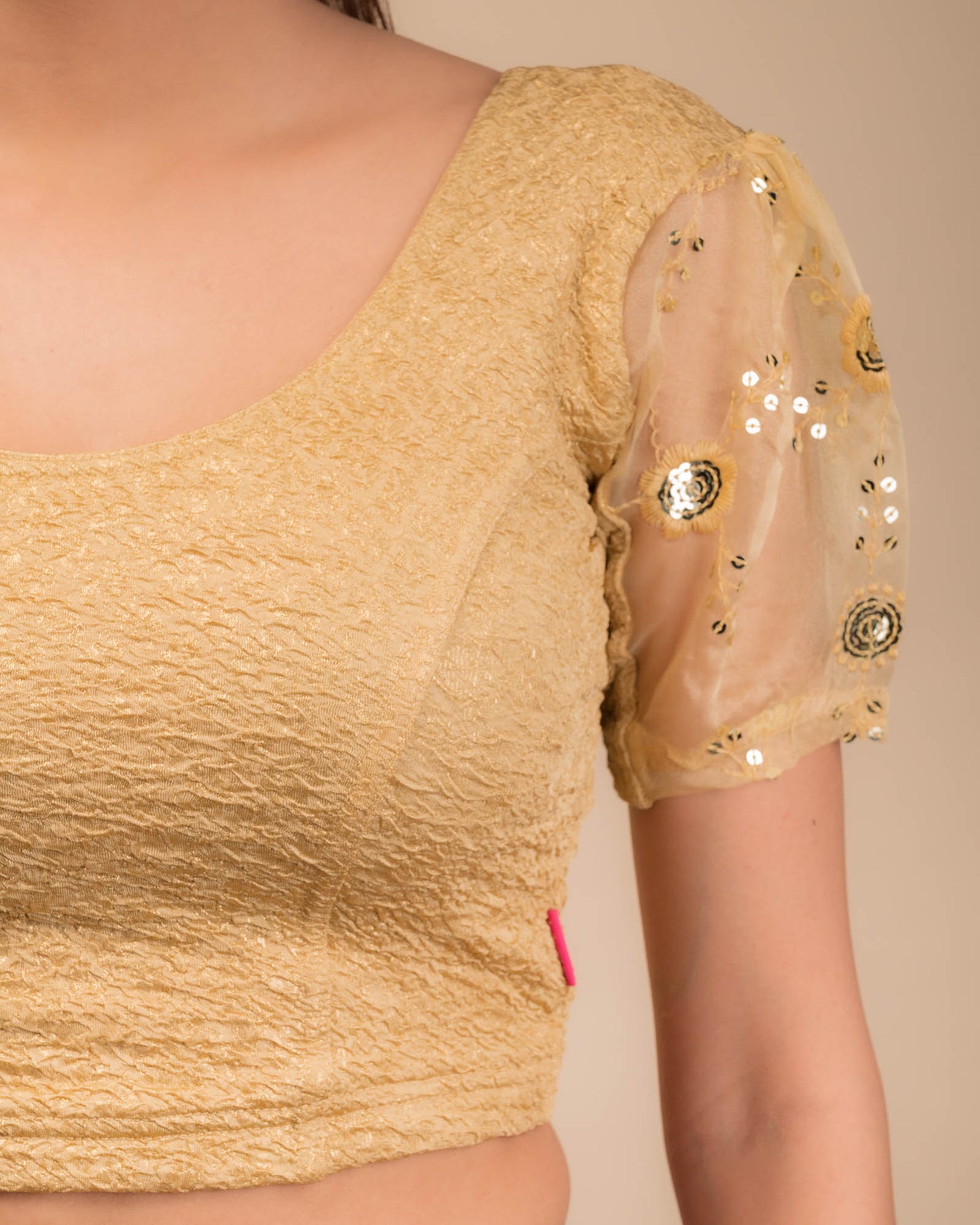  Close-up of textured bodice with sequin embroidery.