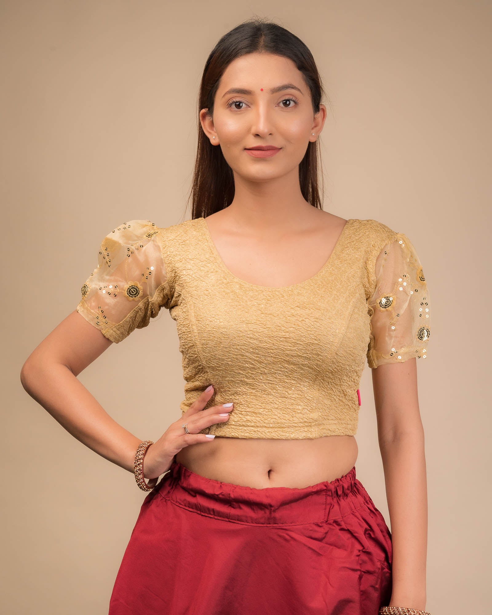Model wearing a stretchable blouse with puff organza sleeves and round neckline.