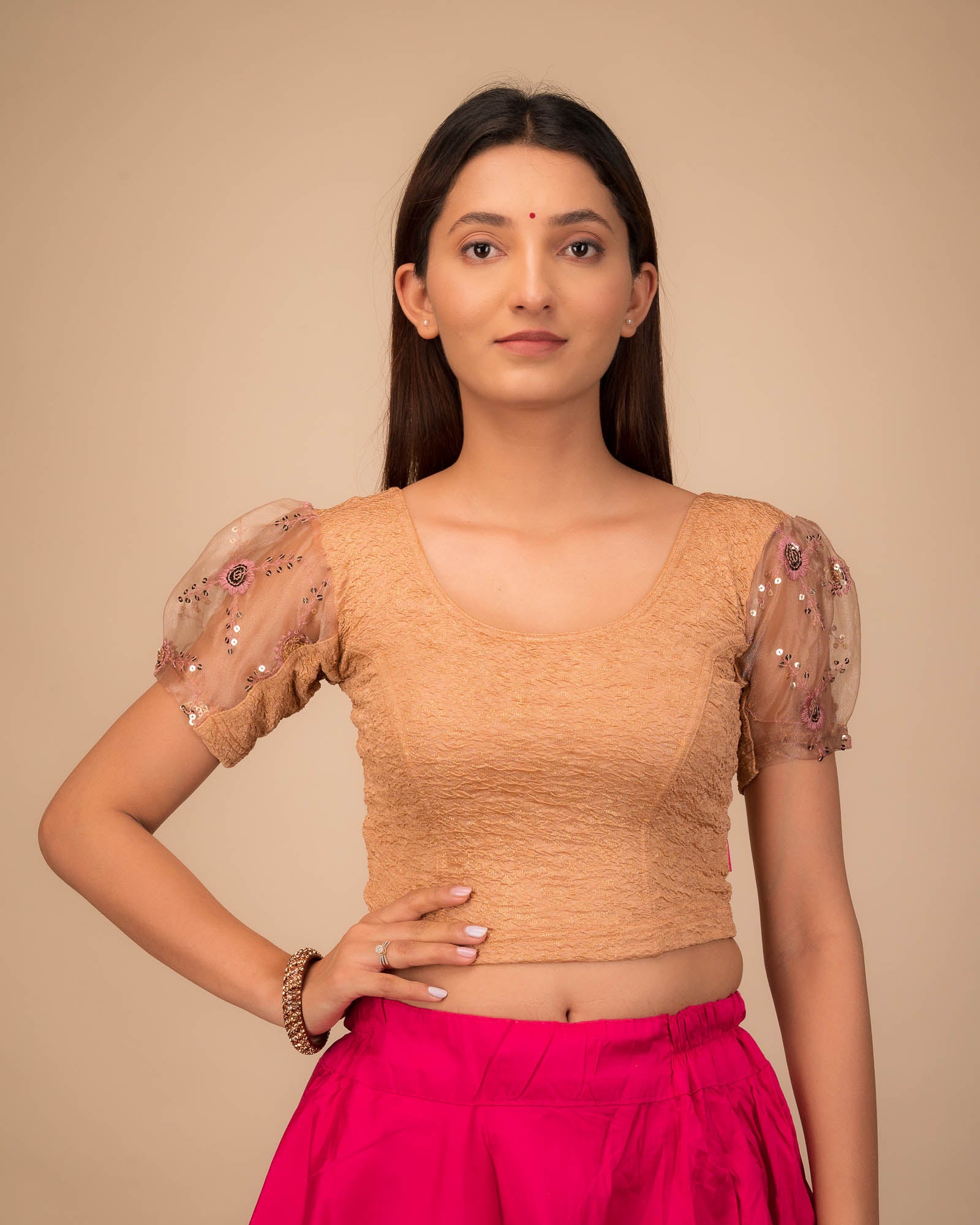 Model wearing a stretchable blouse with puff organza sleeves and round neckline.