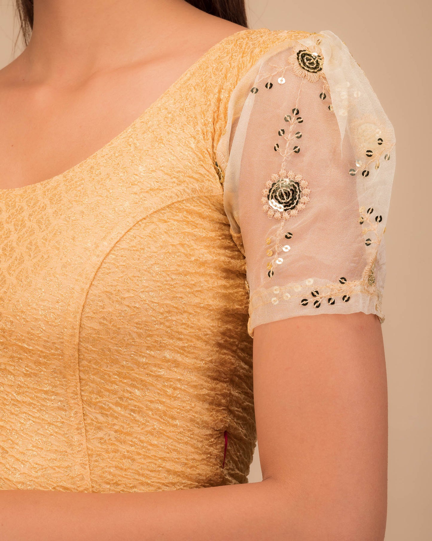 Close-up of textured bodice with sequin embroidery.