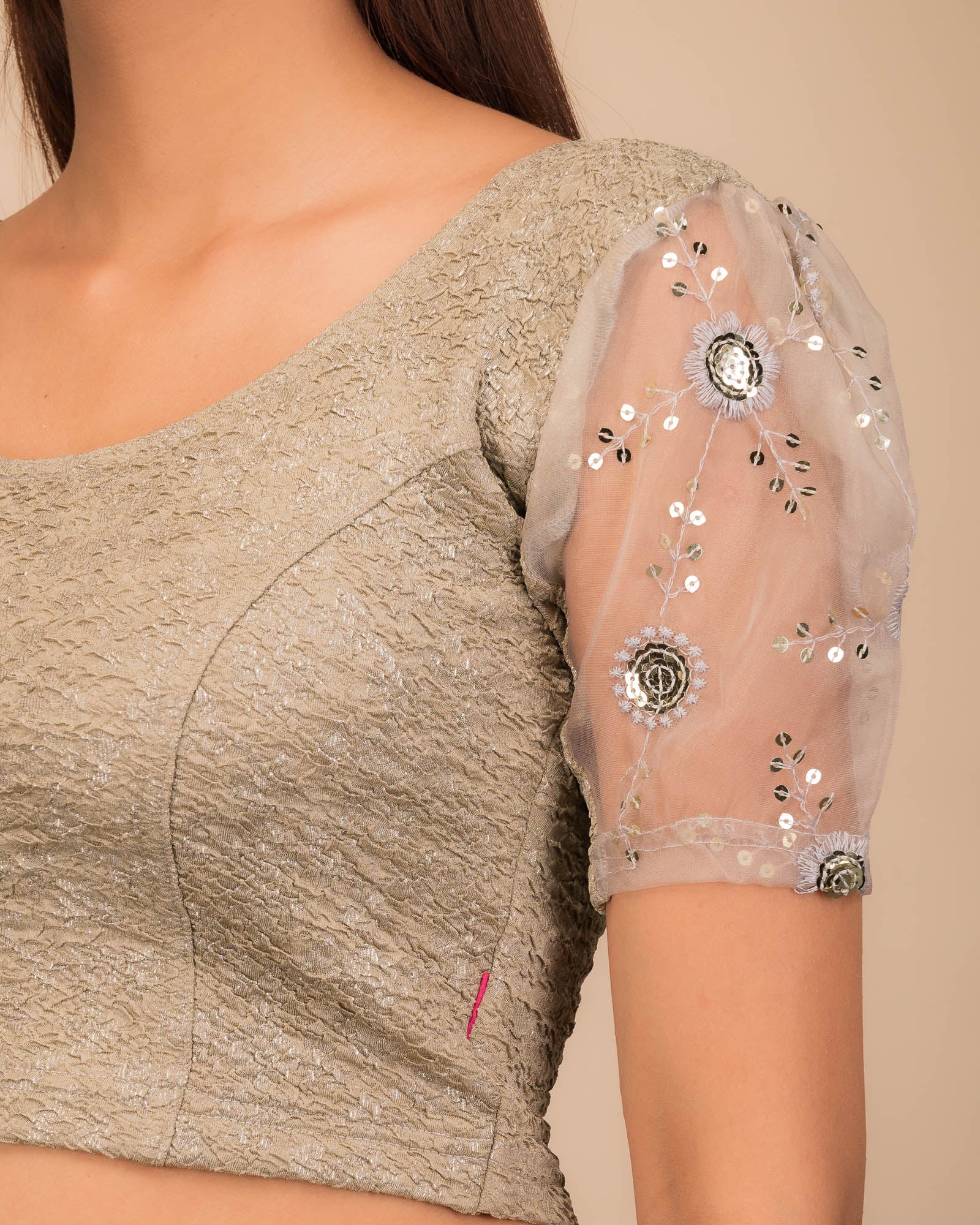 Close-up of textured bodice with sequin embroidery.