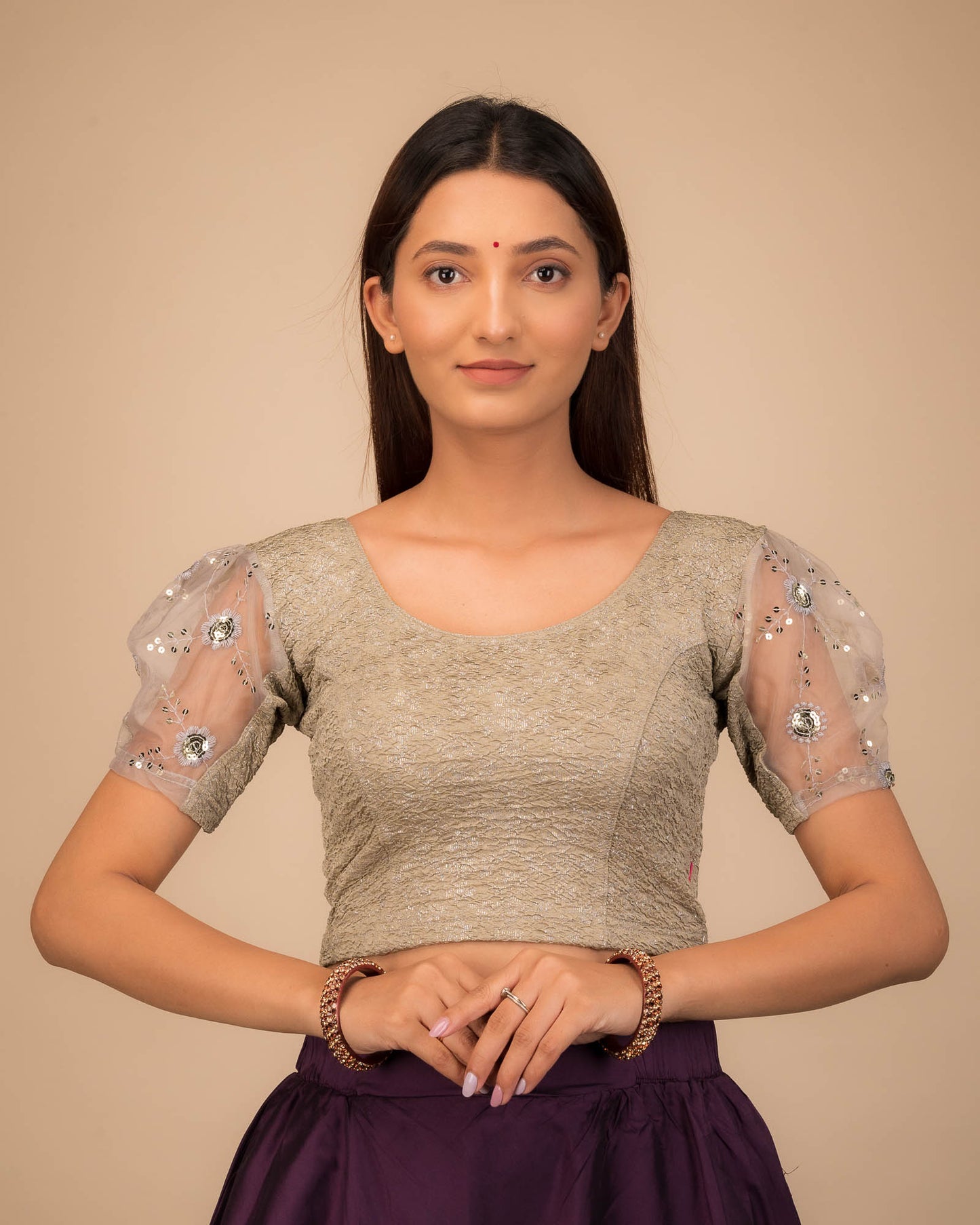 Model wearing a stretchable blouse with puff organza sleeves and round neckline.