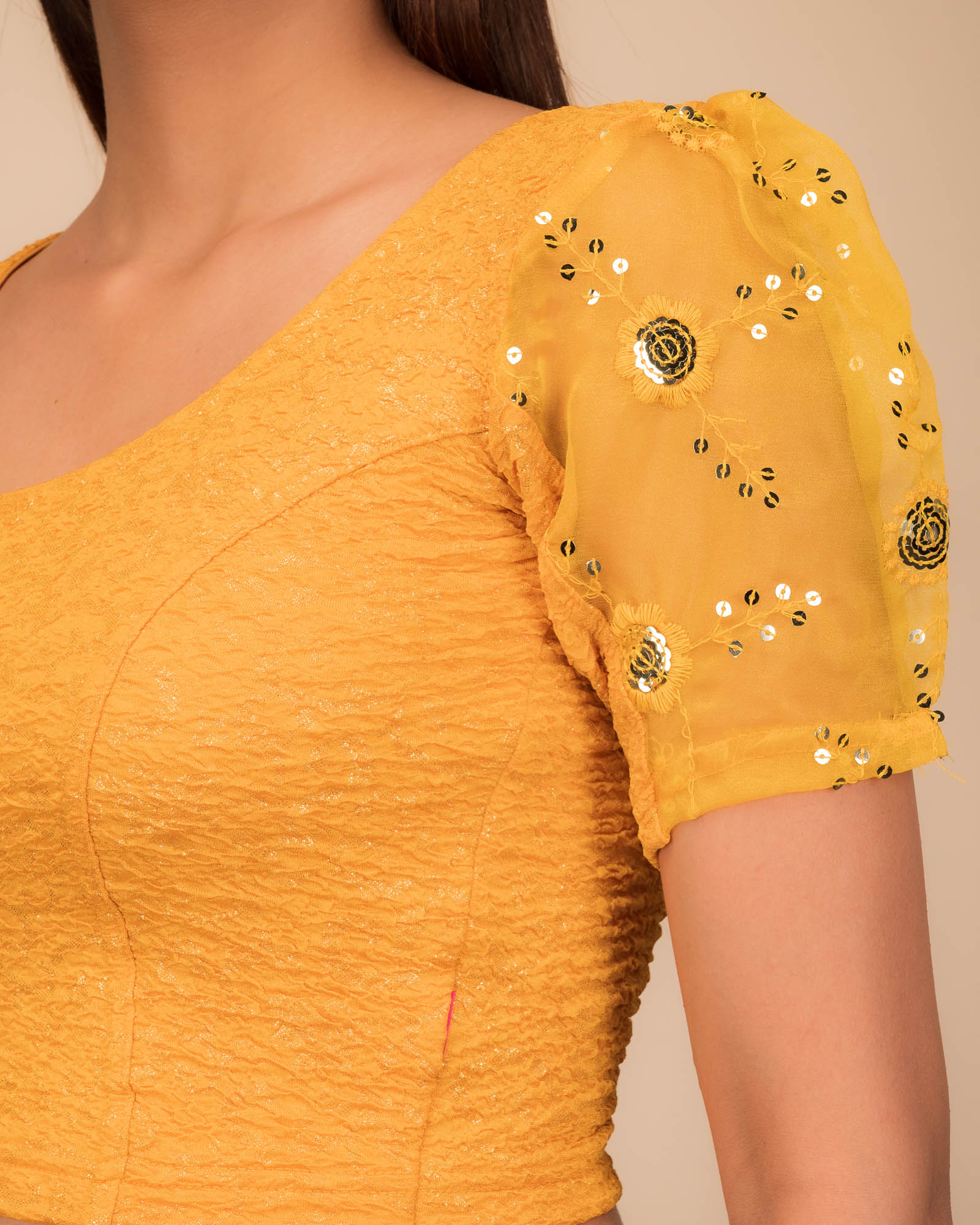 Close-up of textured bodice with sequin embroidery.