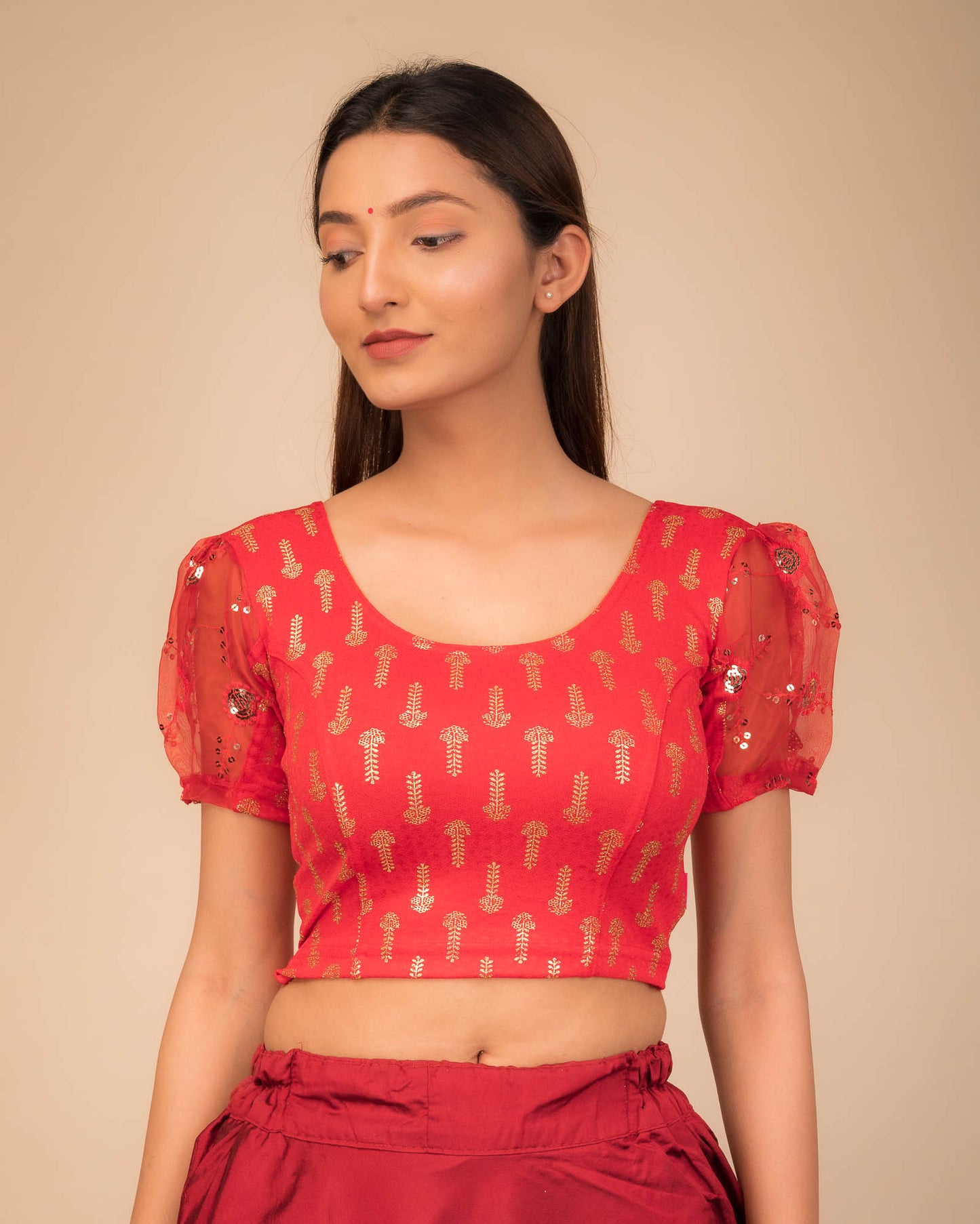 Model wearing a stretchable blouse with puff organza sleeves and round neckline.