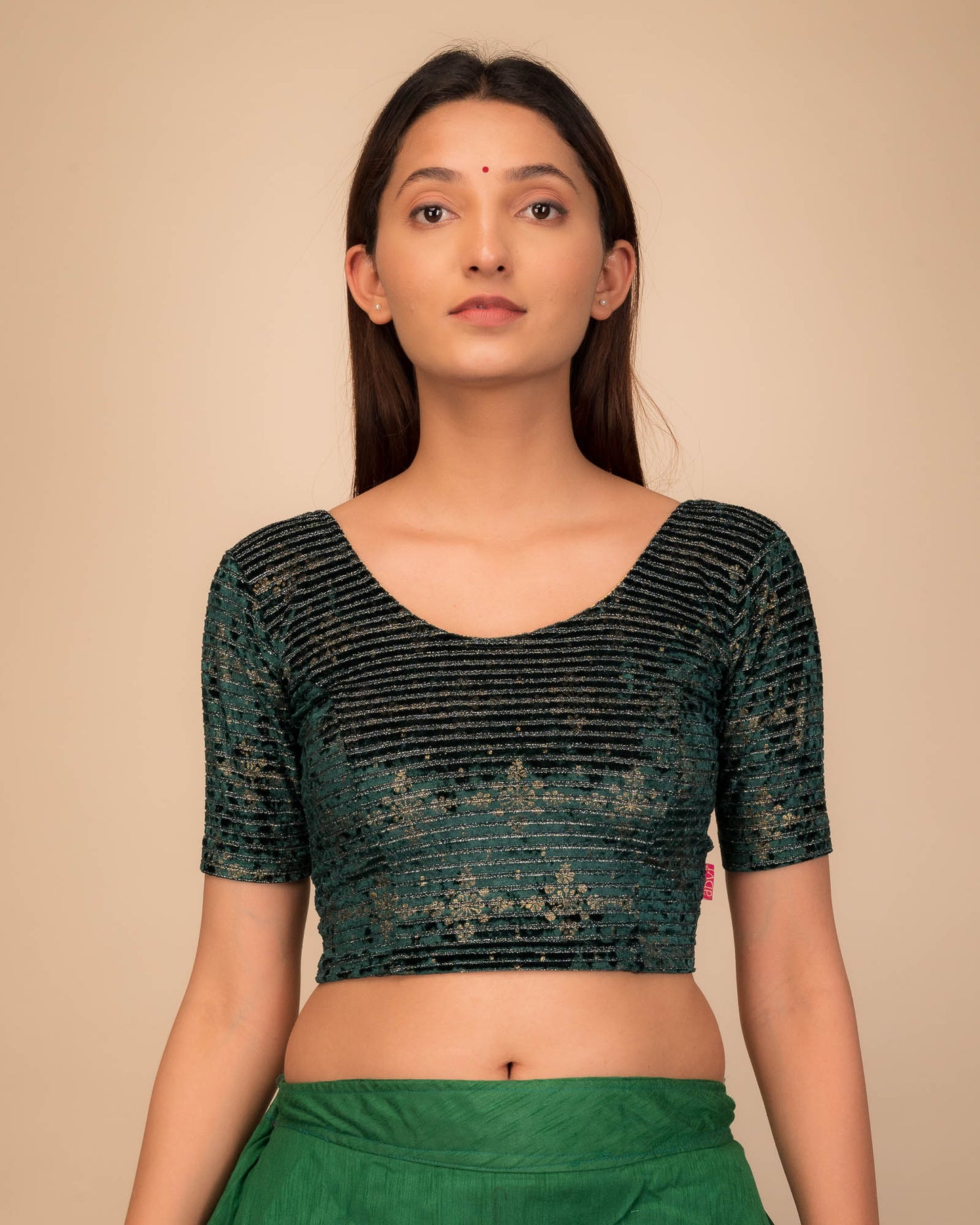 Model wearing a stretchable velvet blouse with elbow sleeves and round neckline.