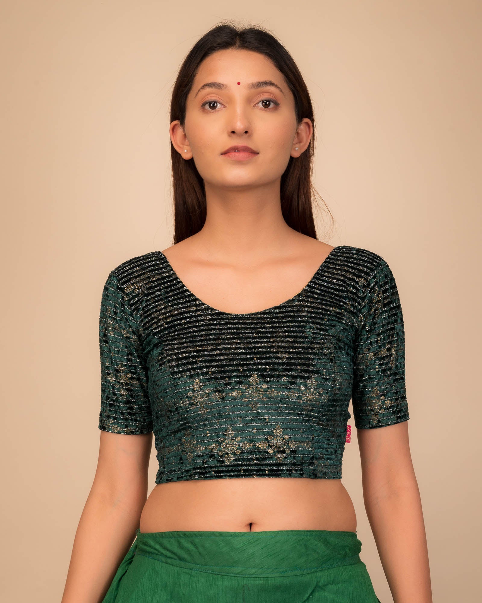 Model wearing a stretchable velvet blouse with elbow sleeves and round neckline.