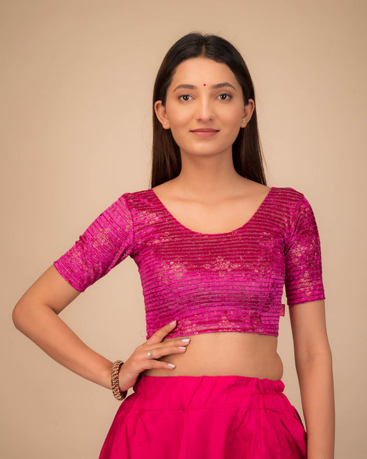 Model wearing a stretchable velvet blouse with elbow sleeves and round neckline.