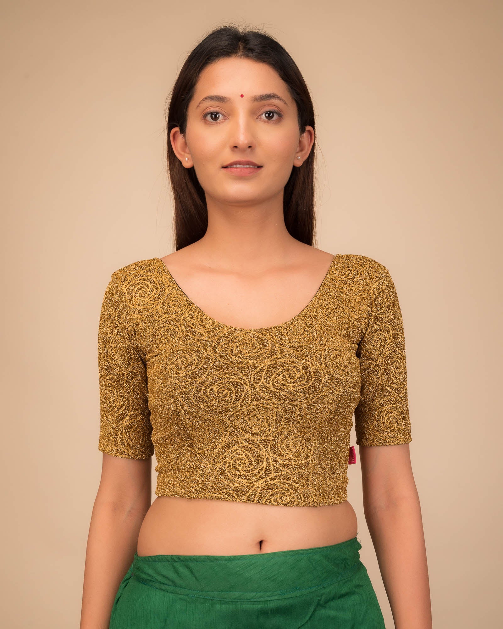 Model wearing a stretchable blouse with elbow sleeves and round neckline, featuring metallic emboss detailing.