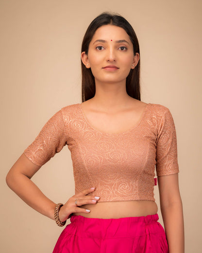 Model wearing a stretchable blouse with elbow sleeves and round neckline, featuring metallic emboss detailing.