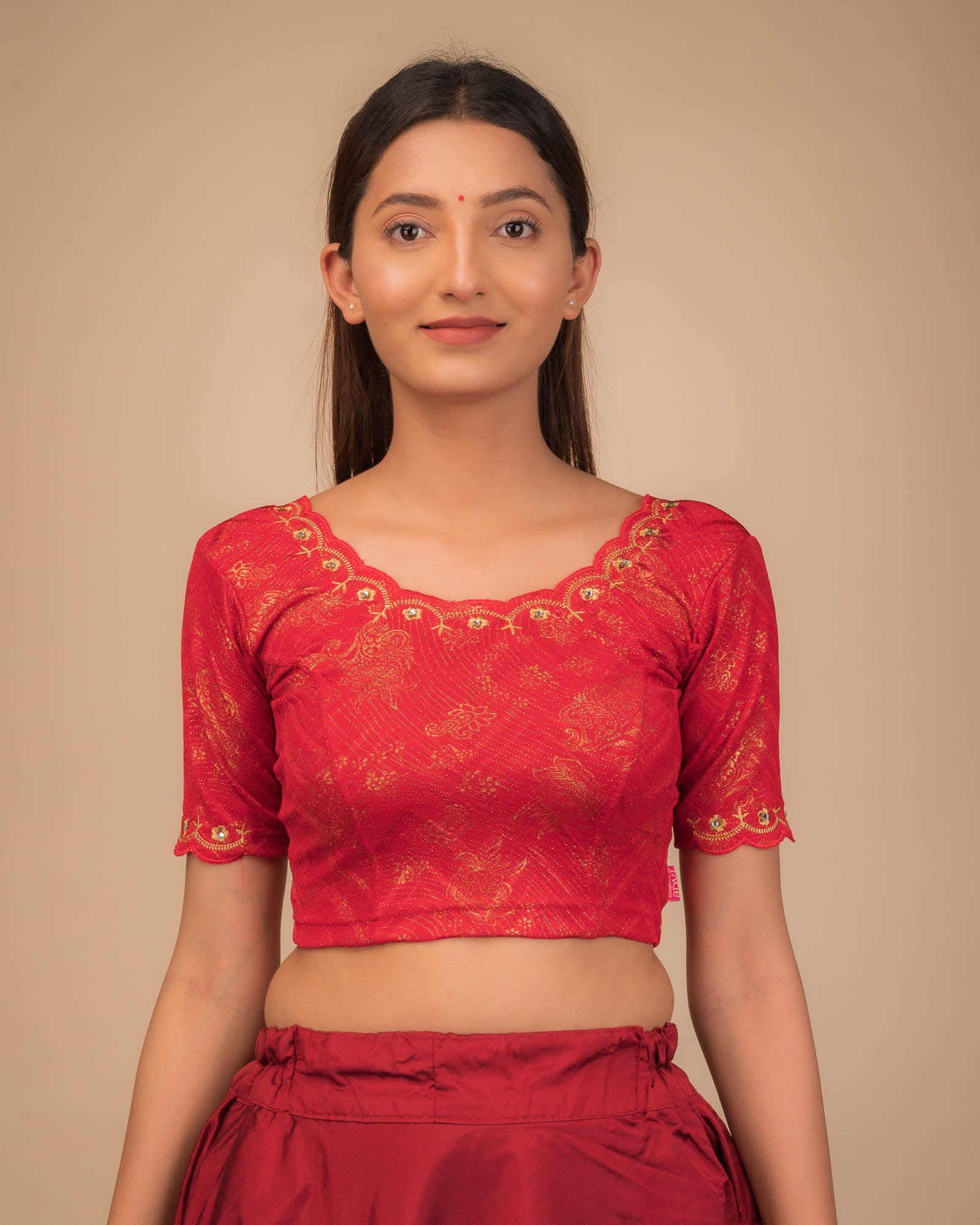 Model wearing a stretchable blouse with scalloped sleeves and round neckline featuring embroidery.