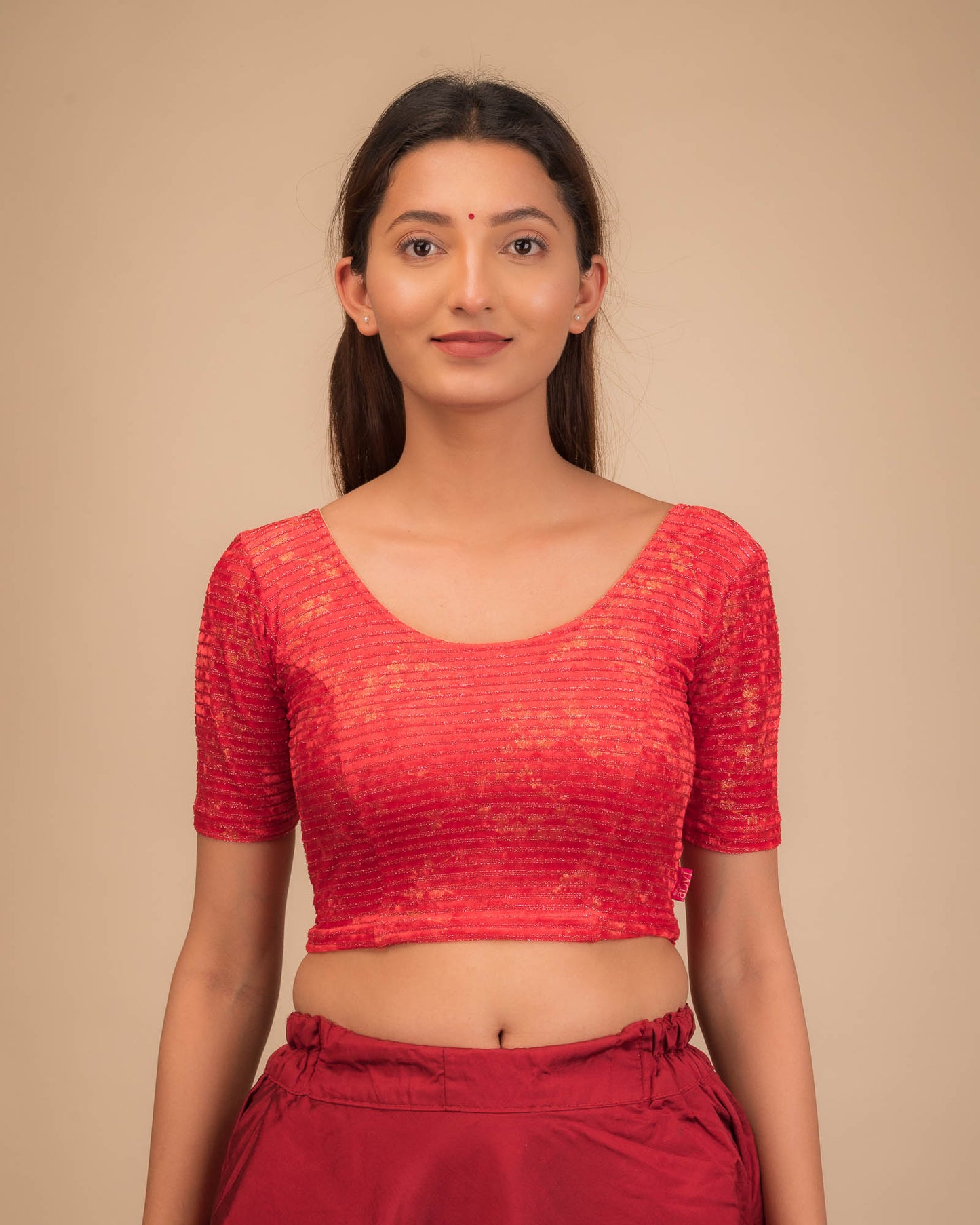 Model wearing a velvet stretchable blouse with elbow sleeves and round neckline.