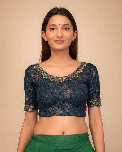 Model wearing a stretchable blouse with elbow sleeves and round neckline, featuring floral embroidery with stone accents.
