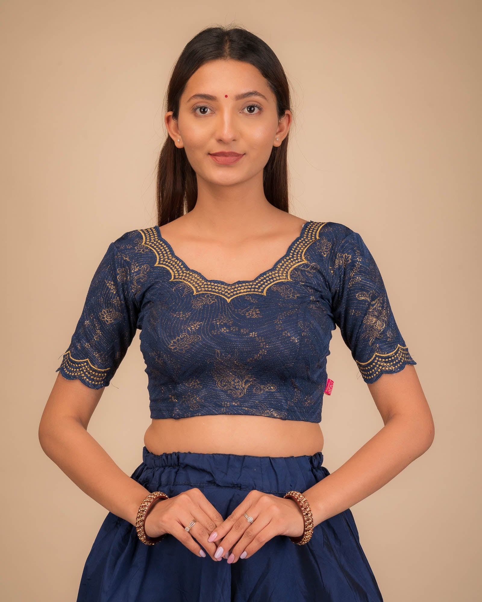 Model wearing a stretchable blouse with elbow sleeves and round neckline, featuring floral embroidery with stone accents.