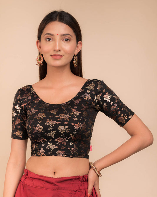 Model wearing a stretchable blouse with elbow sleeves and round neckline, featuring metallic foil floral print.