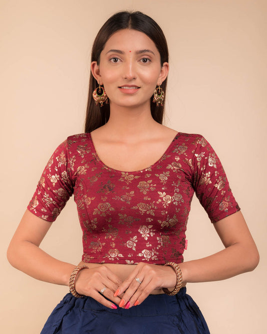 Model wearing a stretchable blouse with elbow sleeves and round neckline, featuring metallic foil floral print.