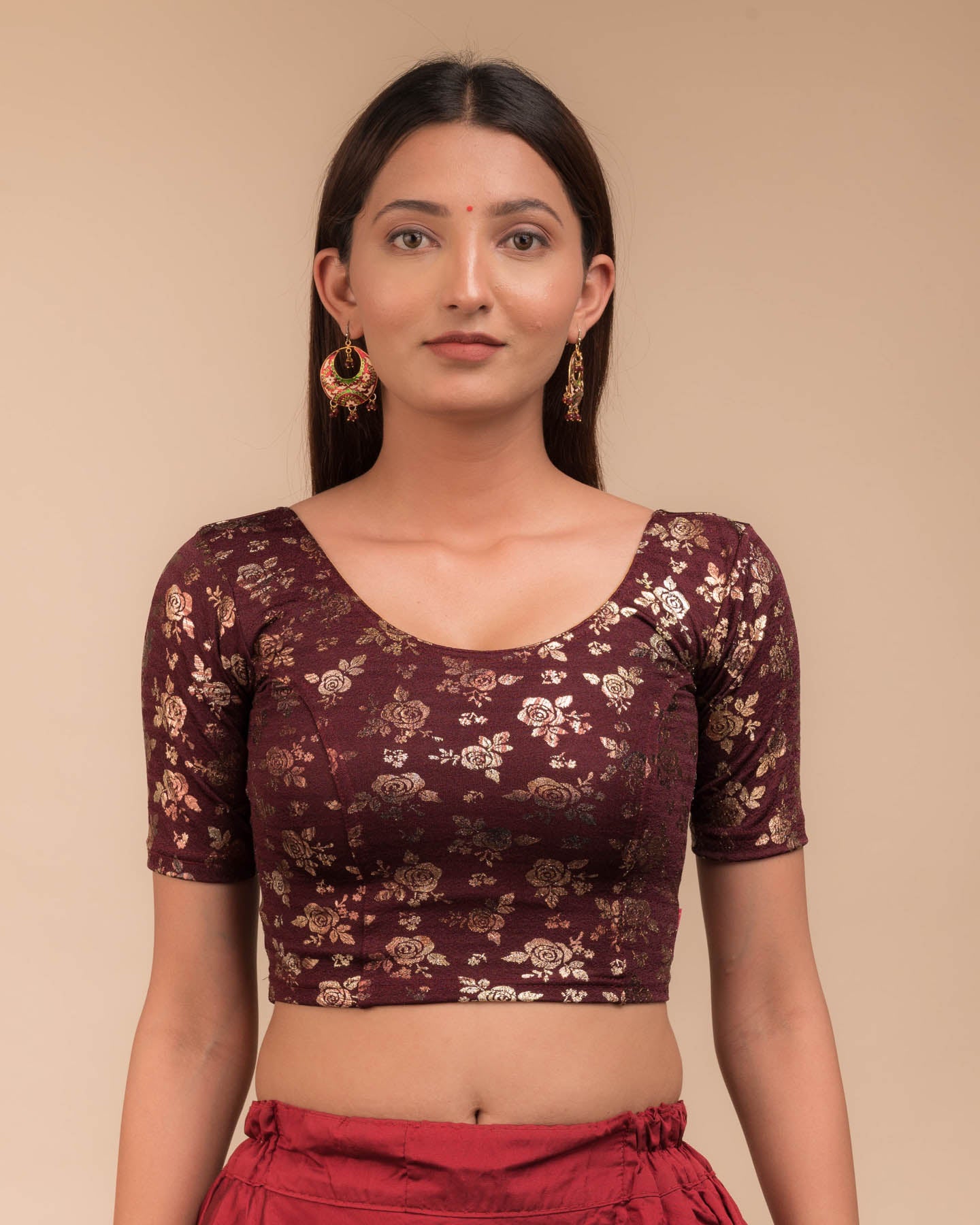 Model wearing a stretchable blouse with elbow sleeves and round neckline, featuring metallic foil floral print.