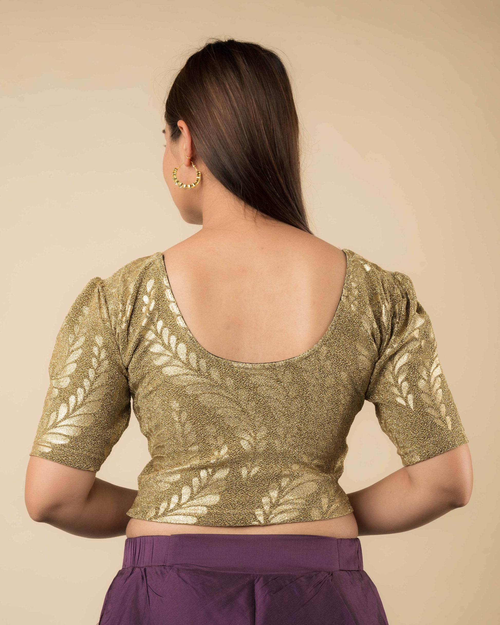 Rear view of the metallic blouse highlighting embossed design and flattering fit.