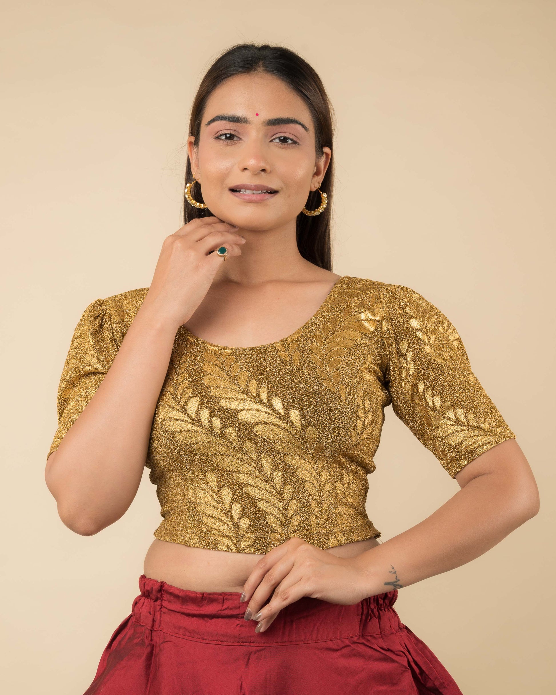 Model wearing metallic zari stretchable blouse with rose print, round neck and elbow sleeves, styled for festive sarees.