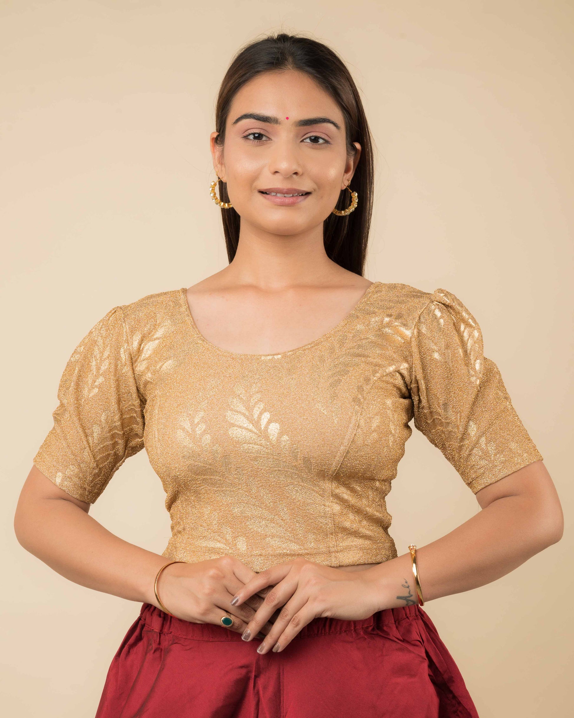 Model wearing metallic zari stretchable blouse with rose print, round neck and elbow sleeves, styled for festive sarees.