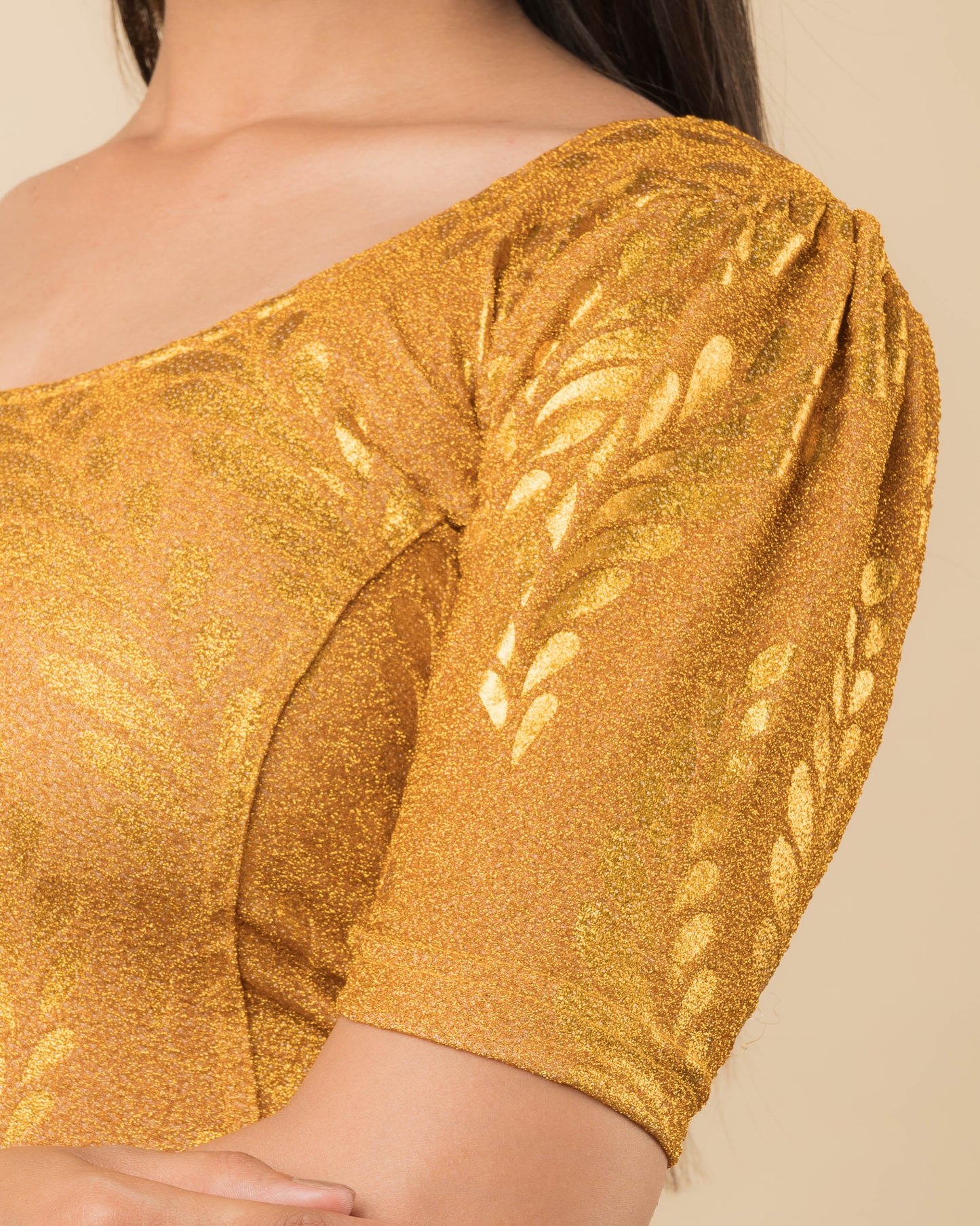 Close-up of metallic zari fabric with detailed rose print texture.