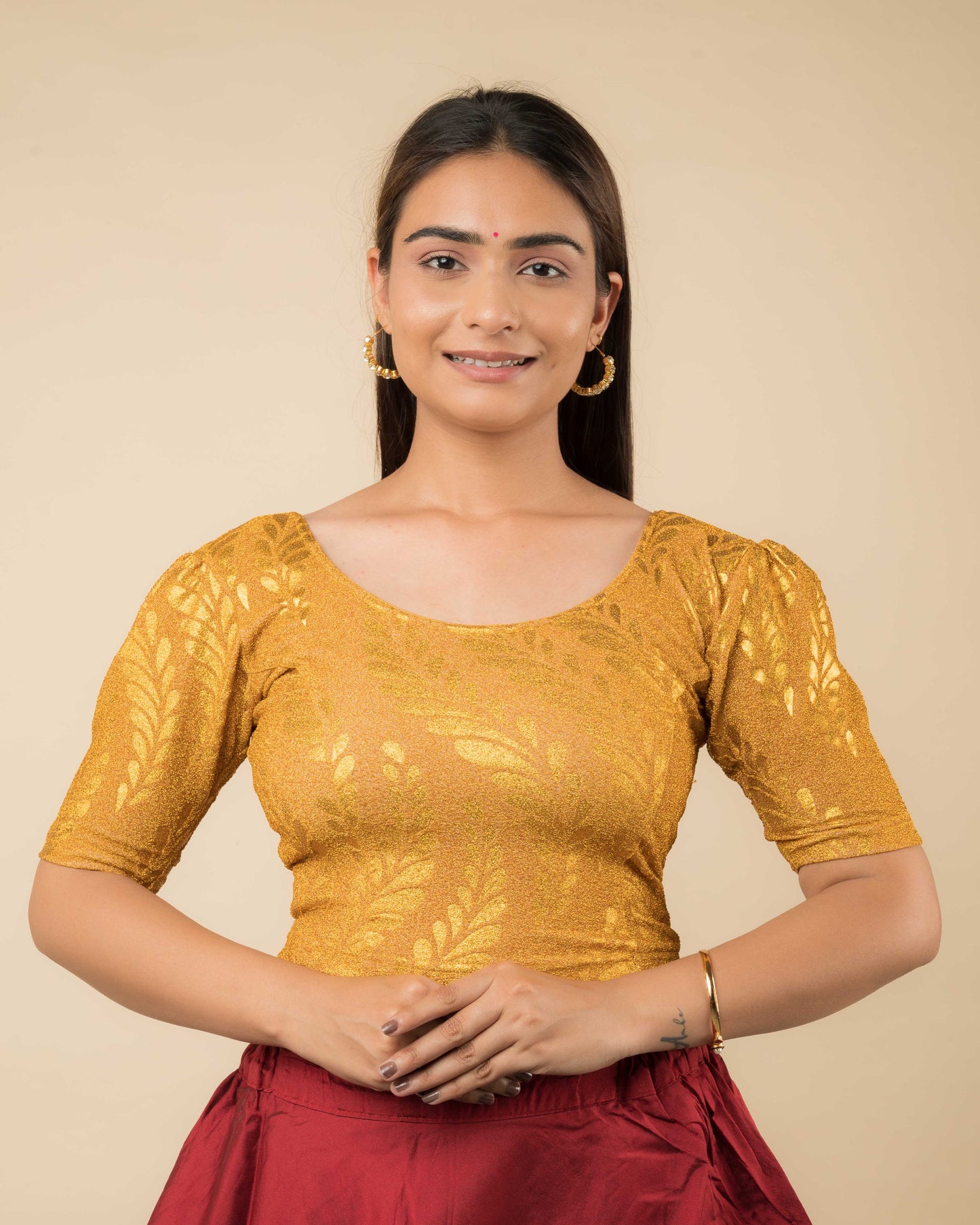 Model wearing metallic zari stretchable blouse with rose print, round neck and elbow sleeves, styled for festive sarees.